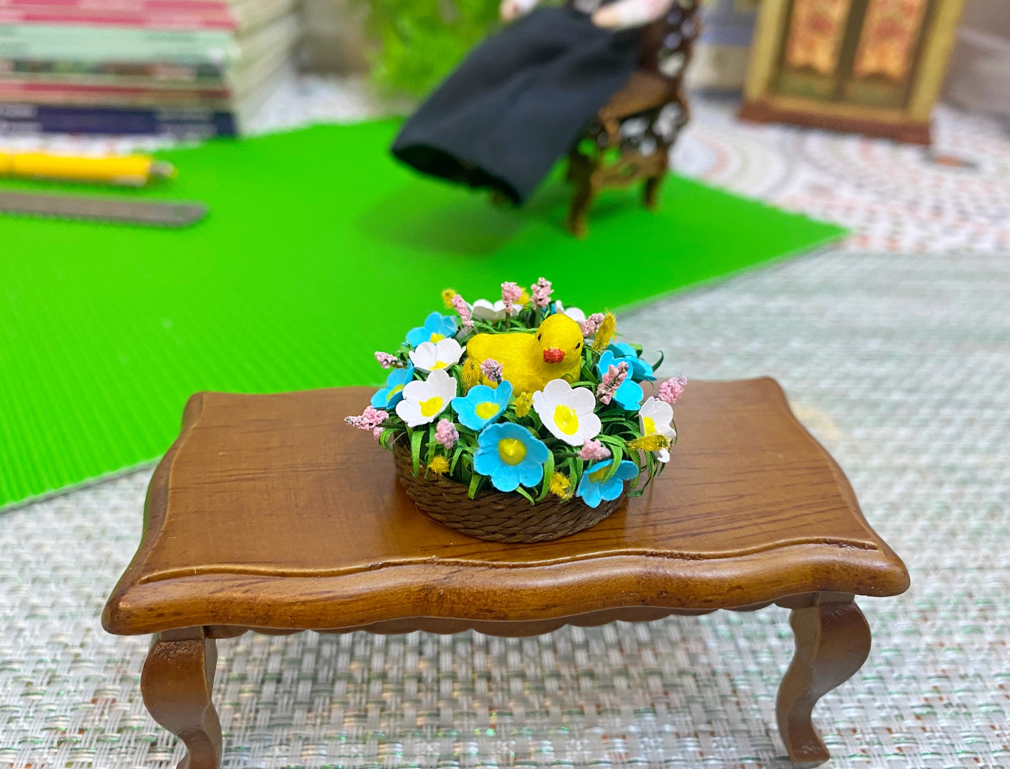 Easter miniature.Chicken in a basket with flowers. Inspire Uplift